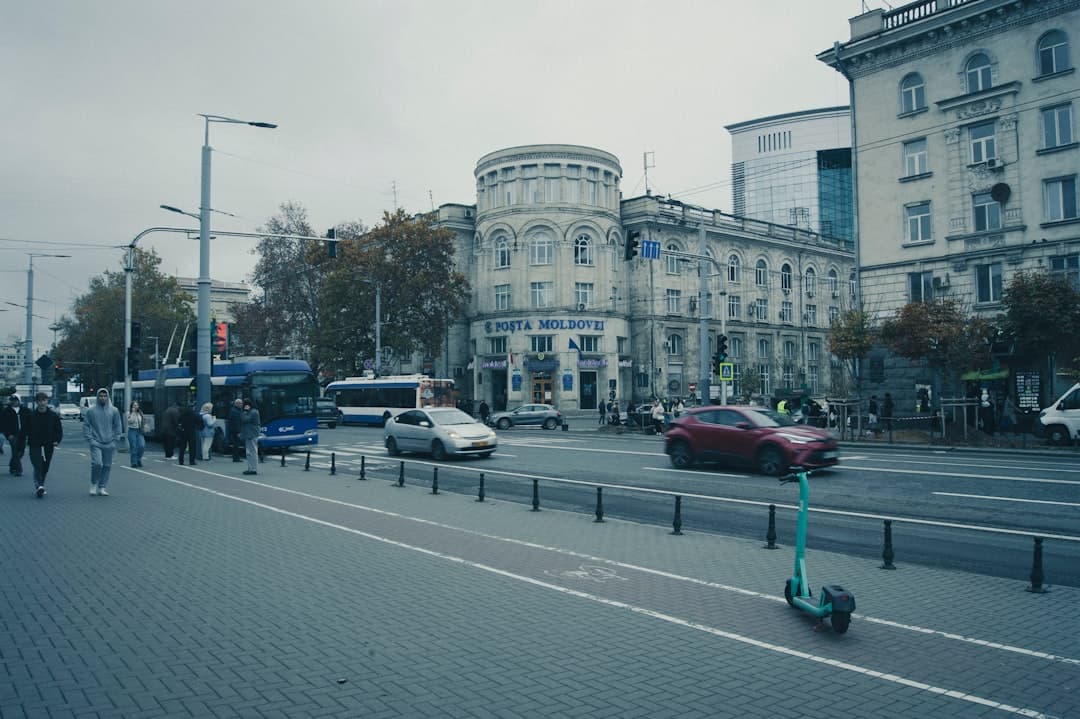 Cars and bus on a city street with buildings.